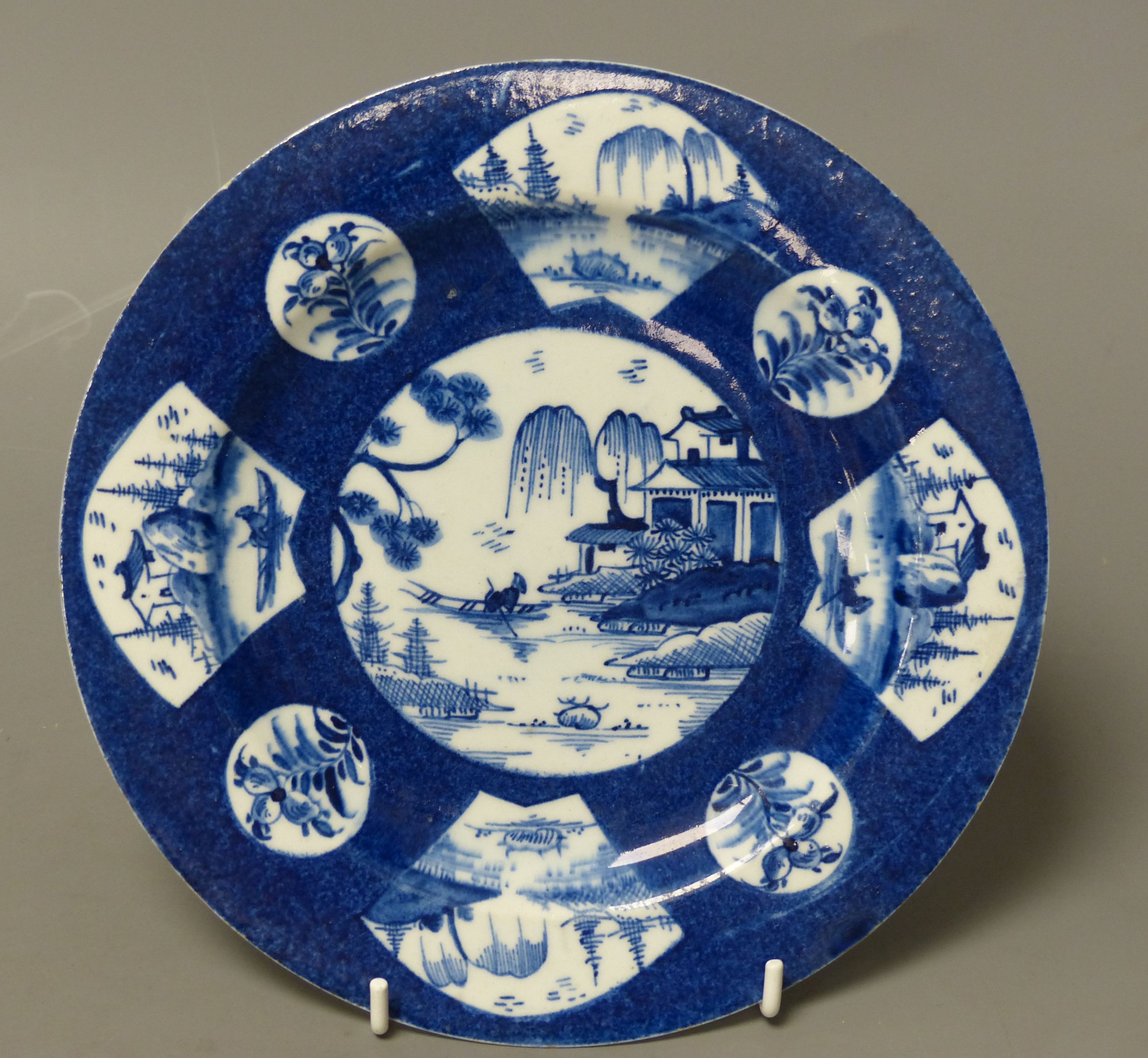 A Bow circular plate painted with landscapes, c.1757, six character mark, 20cm diameter